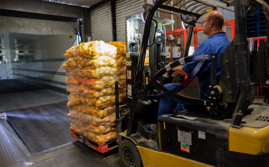 Forklift moving a pallet secured with ReflectorNet pallet netting